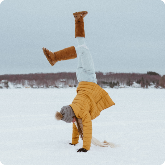 Woman doing a handstand in the snow