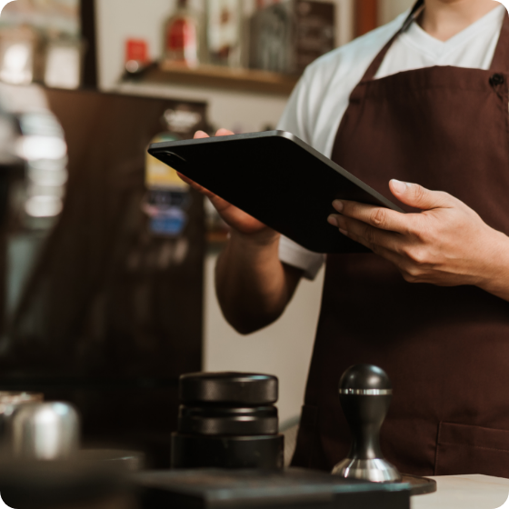 Person wearing an apron working on his tablet