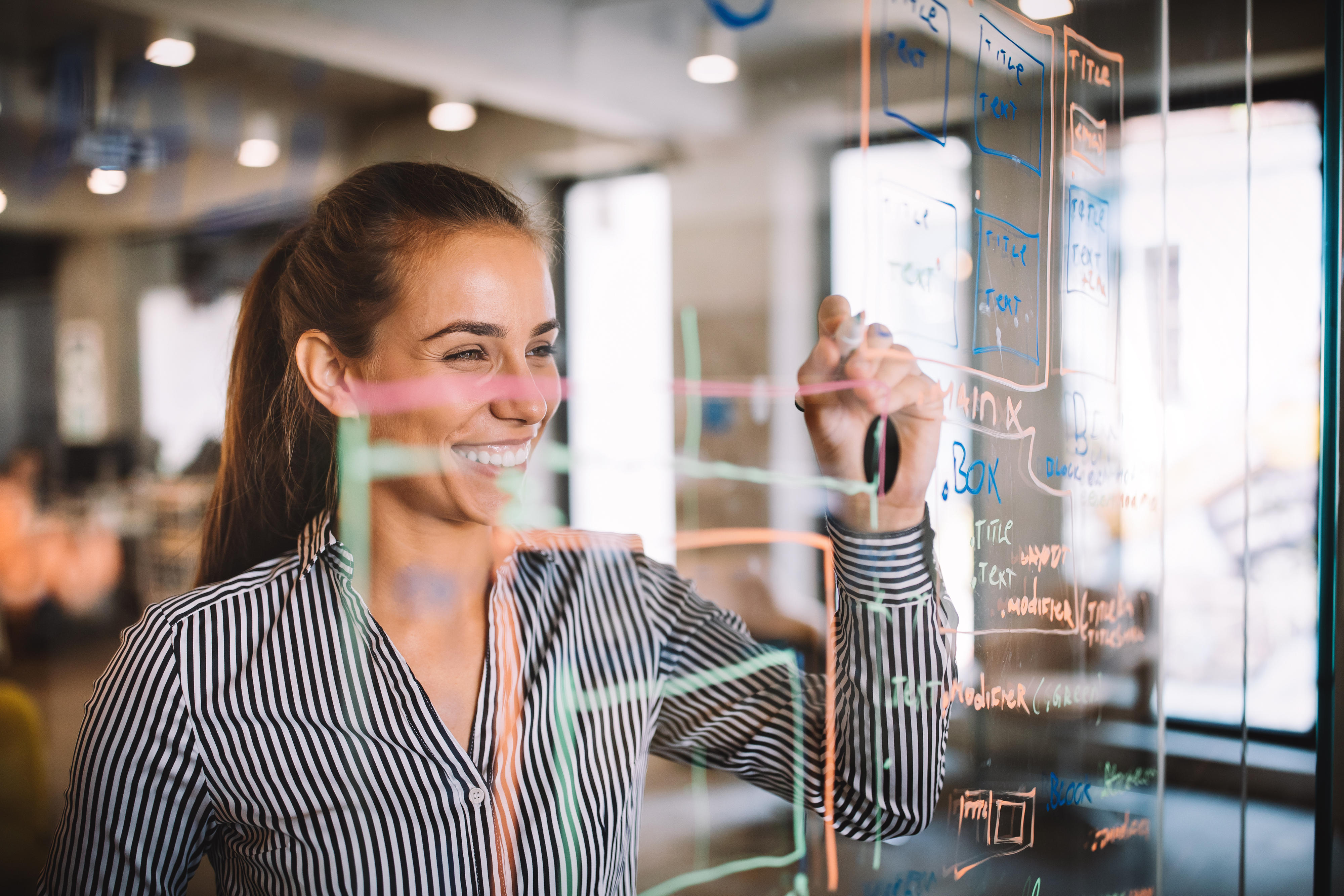 Woman working and writing on the glass board